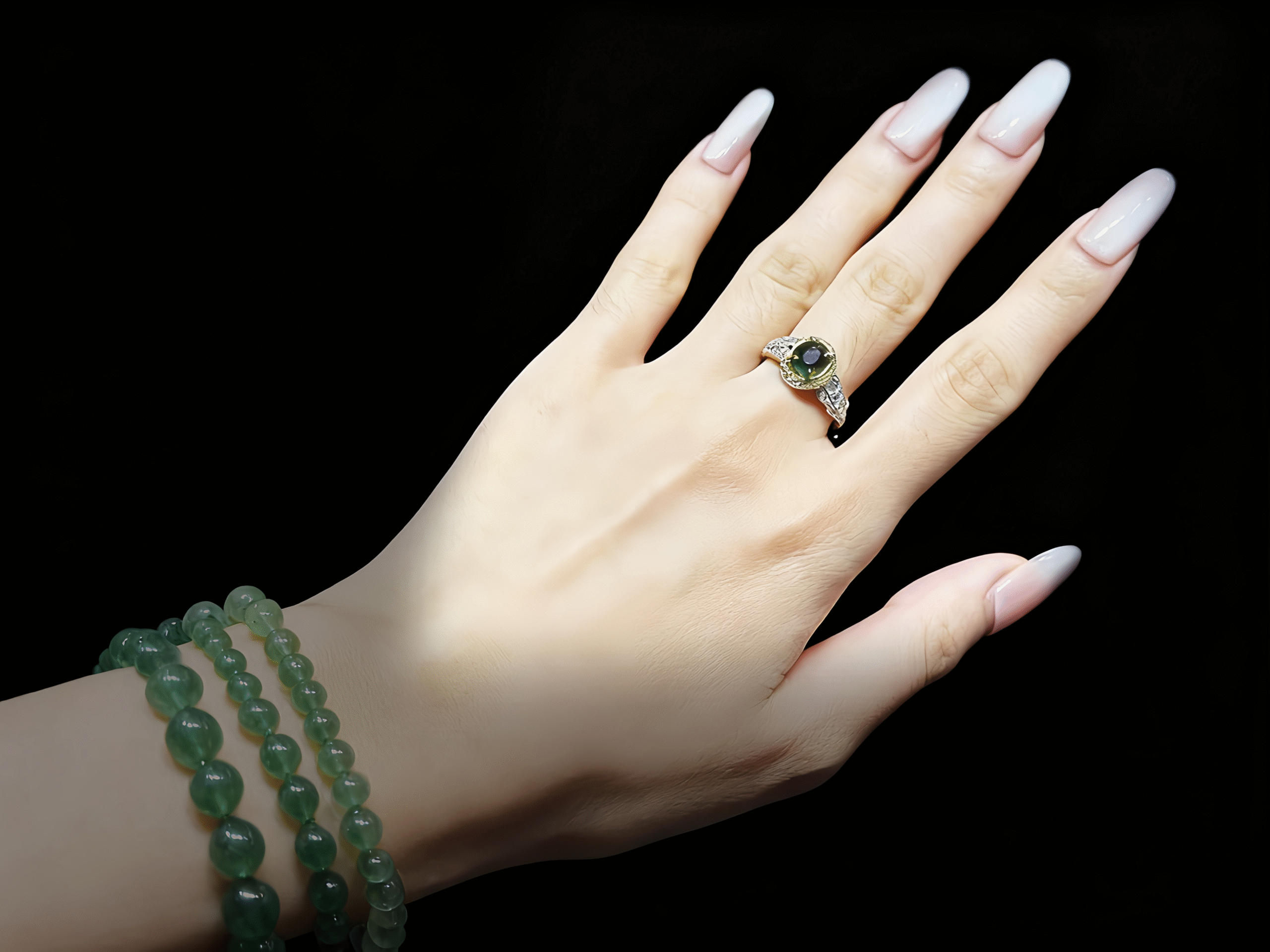 Green Tourmaline ring in a creative studio or serene study, with design sketches or books.