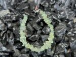 Green Quartz bracelet arranged on a wooden tray with green plants, emphasizing its Wood element properties.